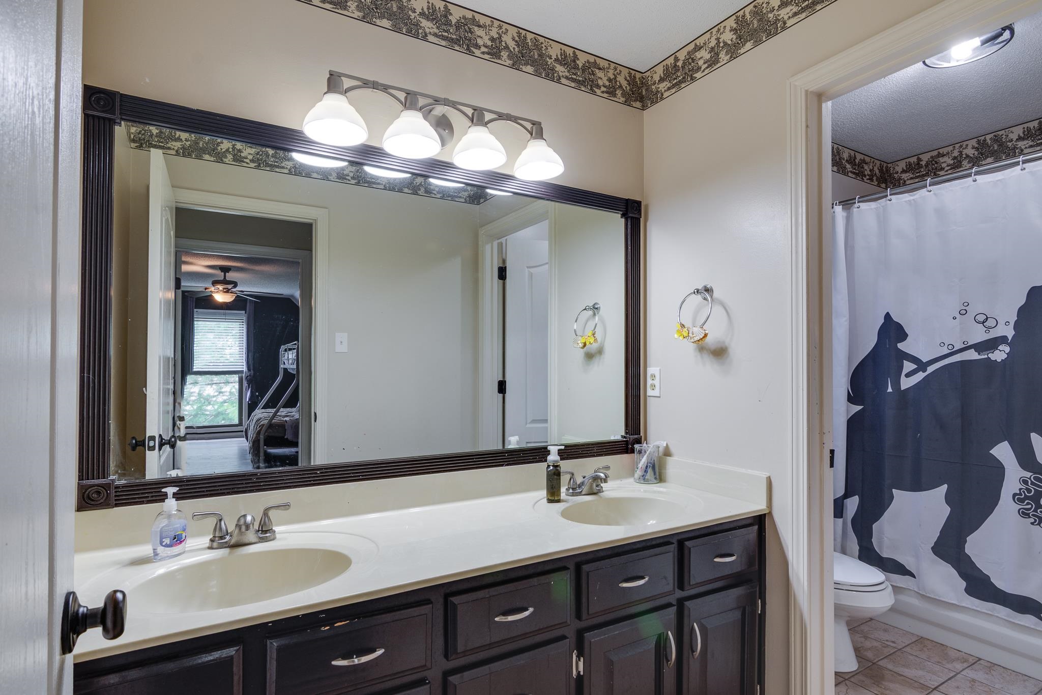 779 Early Earner Cove Collierville, TN 38017 - Photo 20 of 29 Dual vanity with integrated sinks, dark wood-finish cabinetry, and brushed nickel hardware