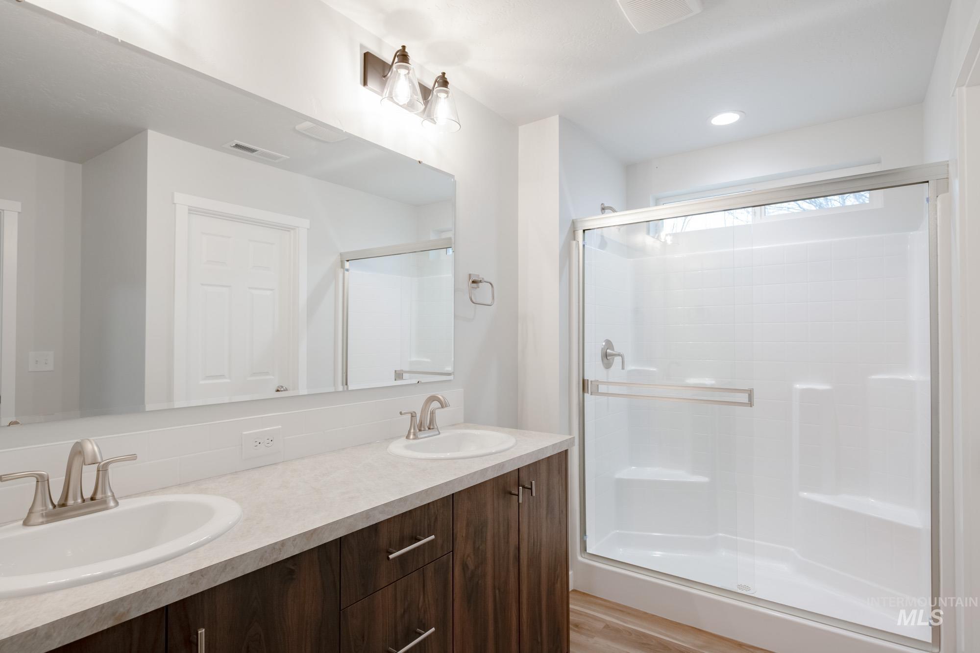 1576 Long Pond Street Middleton, ID 83644 - Photo 20 of 22 Bathroom with double vanity, a shower stall, and light wood-style floors