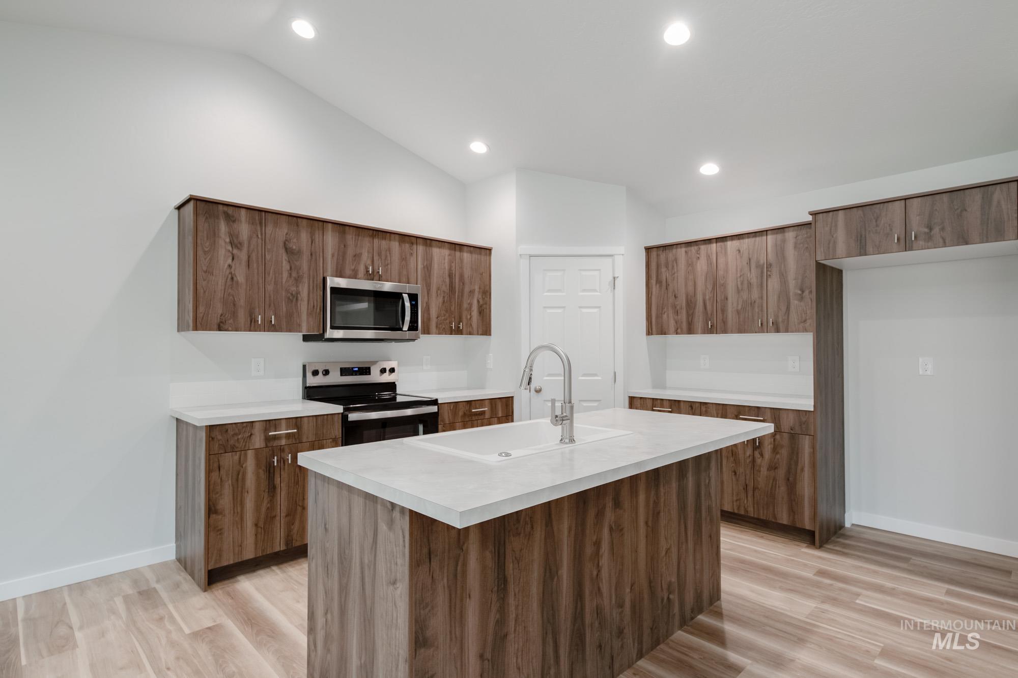 1576 Long Pond Street Middleton, ID 83644 - Photo 4 of 22 Kitchen featuring stainless steel appliances, light countertops, lofted ceiling, light wood finished floors, and recessed lighting