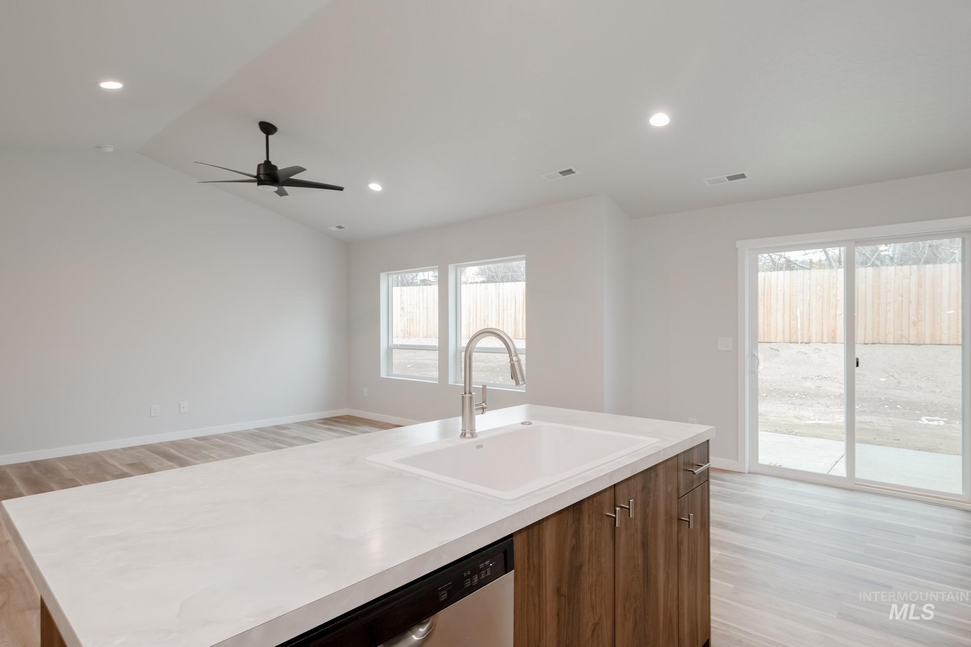 1576 Long Pond Street Middleton, ID 83644 - Photo 6 of 22 Kitchen with light wood-style floors, light countertops, stainless steel dishwasher, recessed lighting, and vaulted ceiling