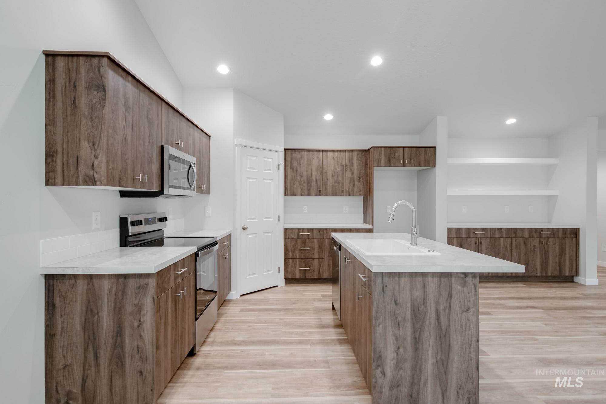 1576 Long Pond Street Middleton, ID 83644 - Photo 7 of 22 Kitchen featuring appliances with stainless steel finishes, light wood-type flooring, modern cabinets, a center island with sink, and recessed lighting