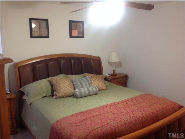 7129 Spanglers Spring Way Raleigh, NC 27610 - Photo 11 of 19 a bedroom with a bed and a lamp