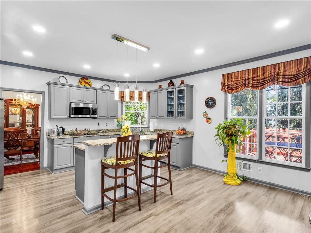 2354 Brentmoore Point Conyers, GA 30013 - Photo 20 of 91 a kitchen with stainless steel appliances granite countertop a stove top oven a sink dishwasher a dining table and chairs with wooden floor