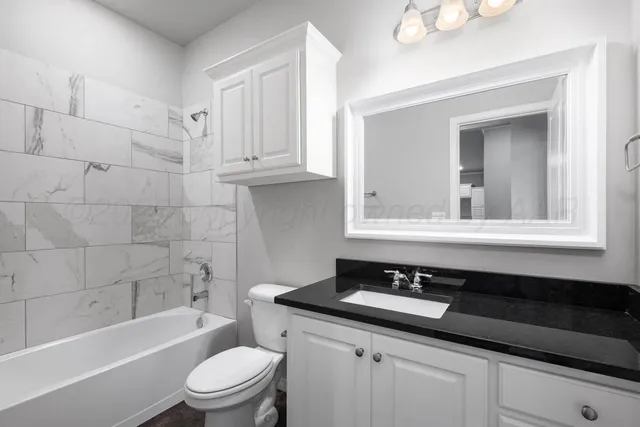 a bathroom with a sink a toilet a mirror and bathtub