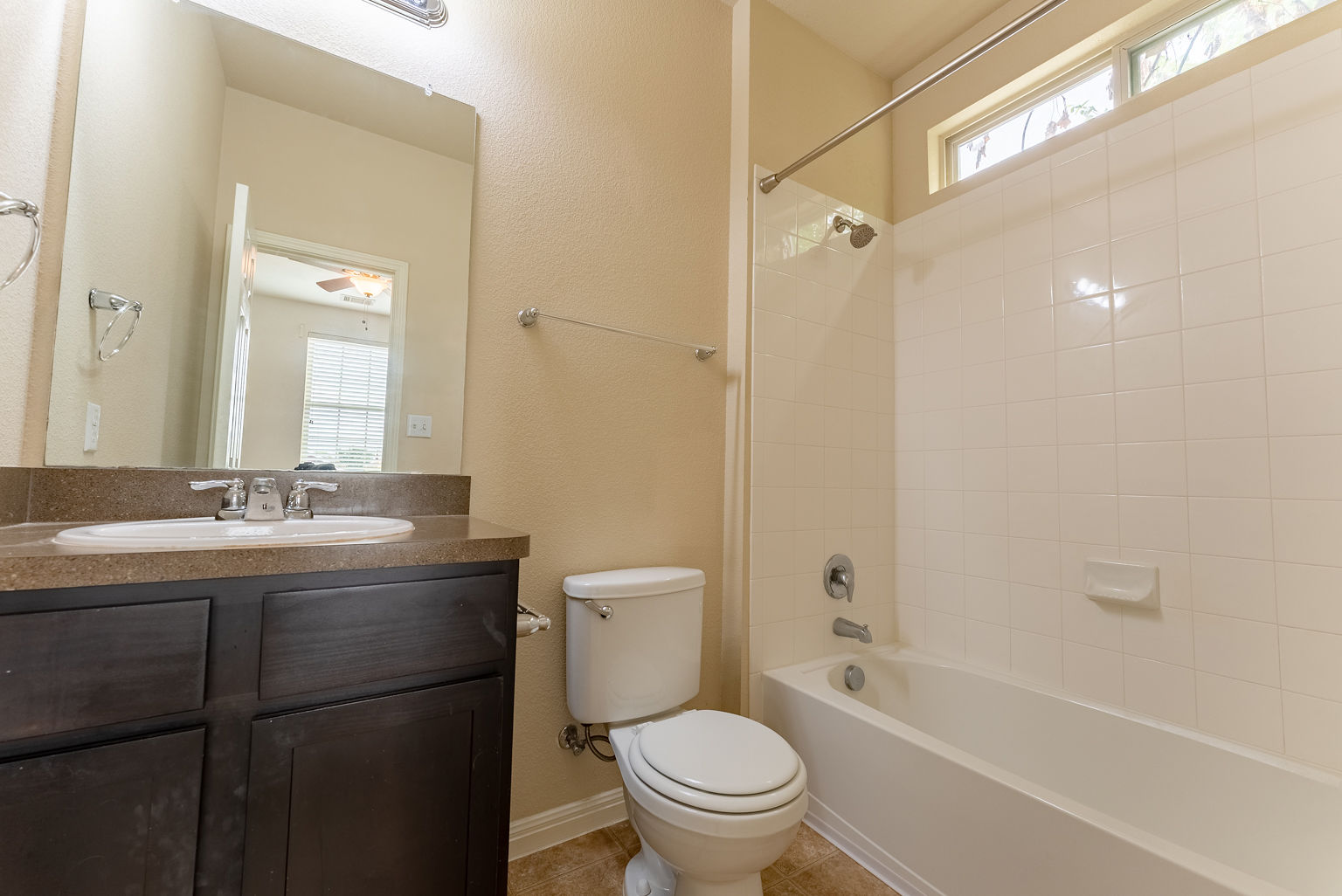 4514 Senda Lane Austin, TX 78725 - Photo 22 of 25 a bathroom with a granite countertop toilet a sink and a bathtub
