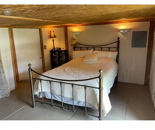 a bed sitting in a bedroom next to a window