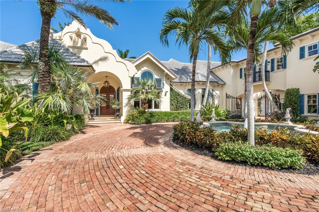 a view of a white house with a yard and potted plants