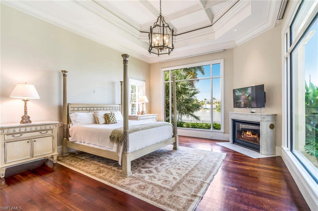 3275 Green Dolphin Lane Naples, FL 34102 - Photo 11 of 35 a spacious bedroom with a bed and a fireplace