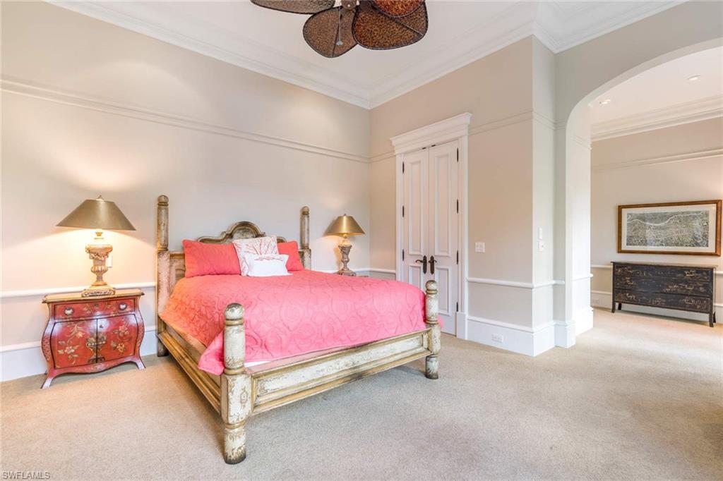 3275 Green Dolphin Lane Naples, FL 34102 - Photo 15 of 35 a spacious bedroom with a bed and a chandelier