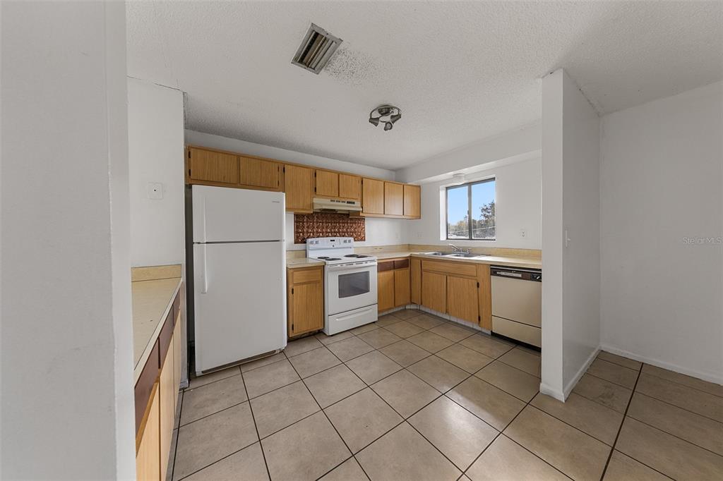 2547 Myrtle Avenue Sanford, FL 32773 - Photo 3 of 13 a kitchen with a sink a refrigerator and cabinets