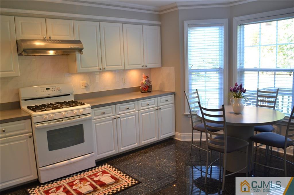 19 Dickerson Lane, Unit X Old Bridge, NJ 08857 - Photo 7 of 25 a kitchen with stainless steel appliances a stove a sink and white cabinets