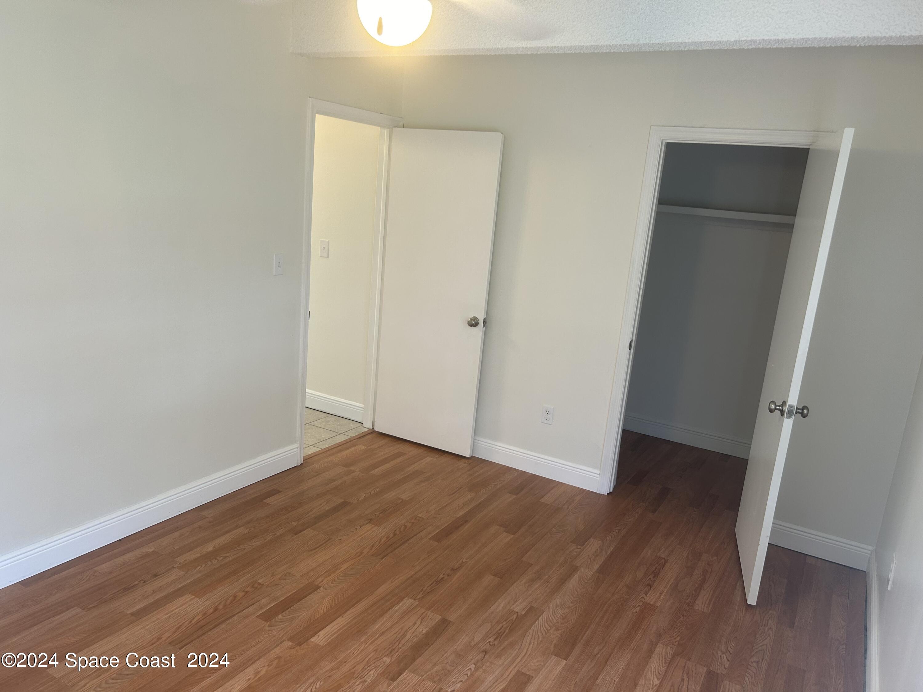 2808 Starlight Circle Northeast Palm Bay, FL 32905 - Photo 12 of 15 an empty room with wooden floor and closet
