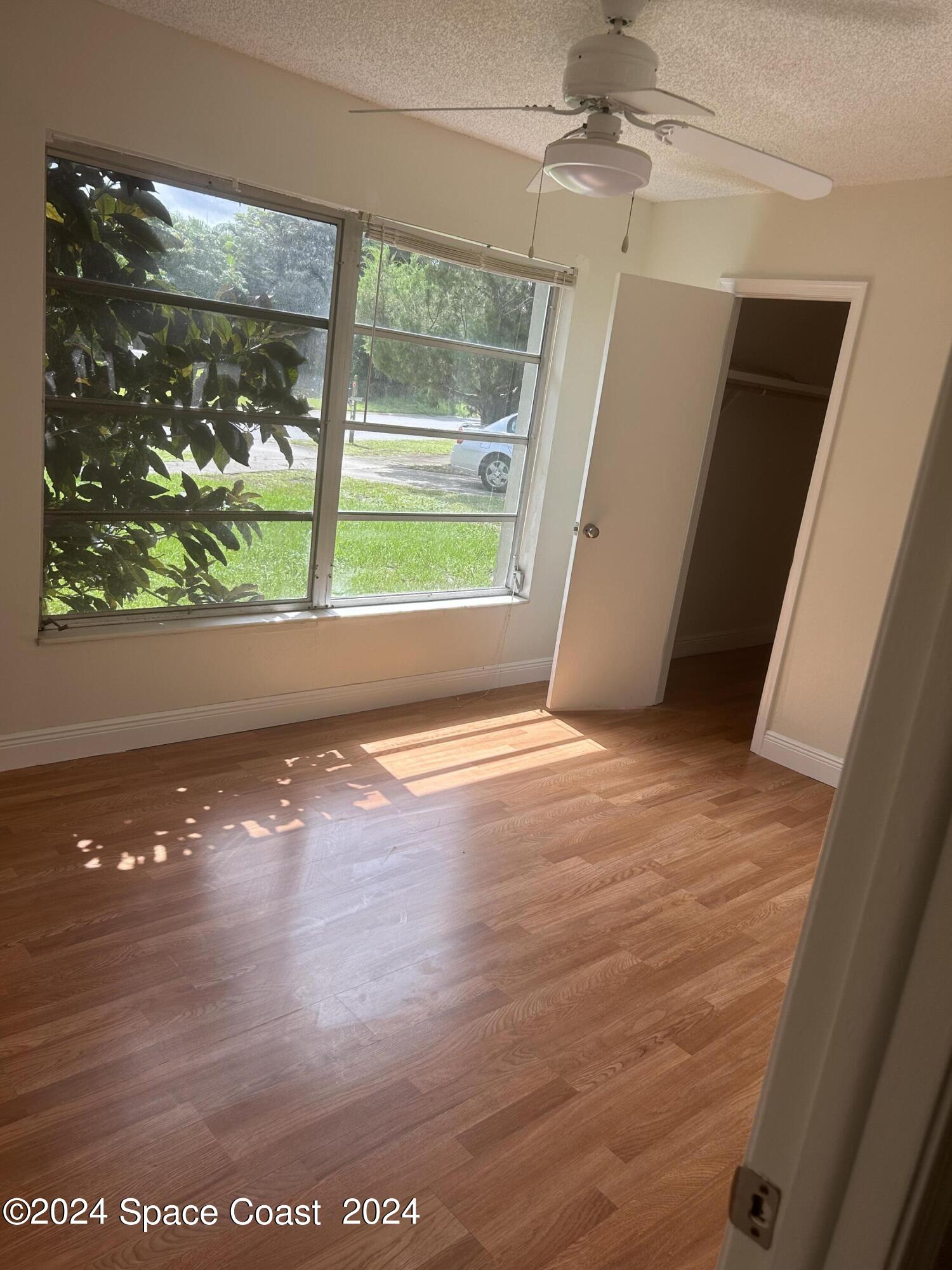 2808 Starlight Circle Northeast Palm Bay, FL 32905 - Photo 13 of 15 an empty room with wooden floor and windows
