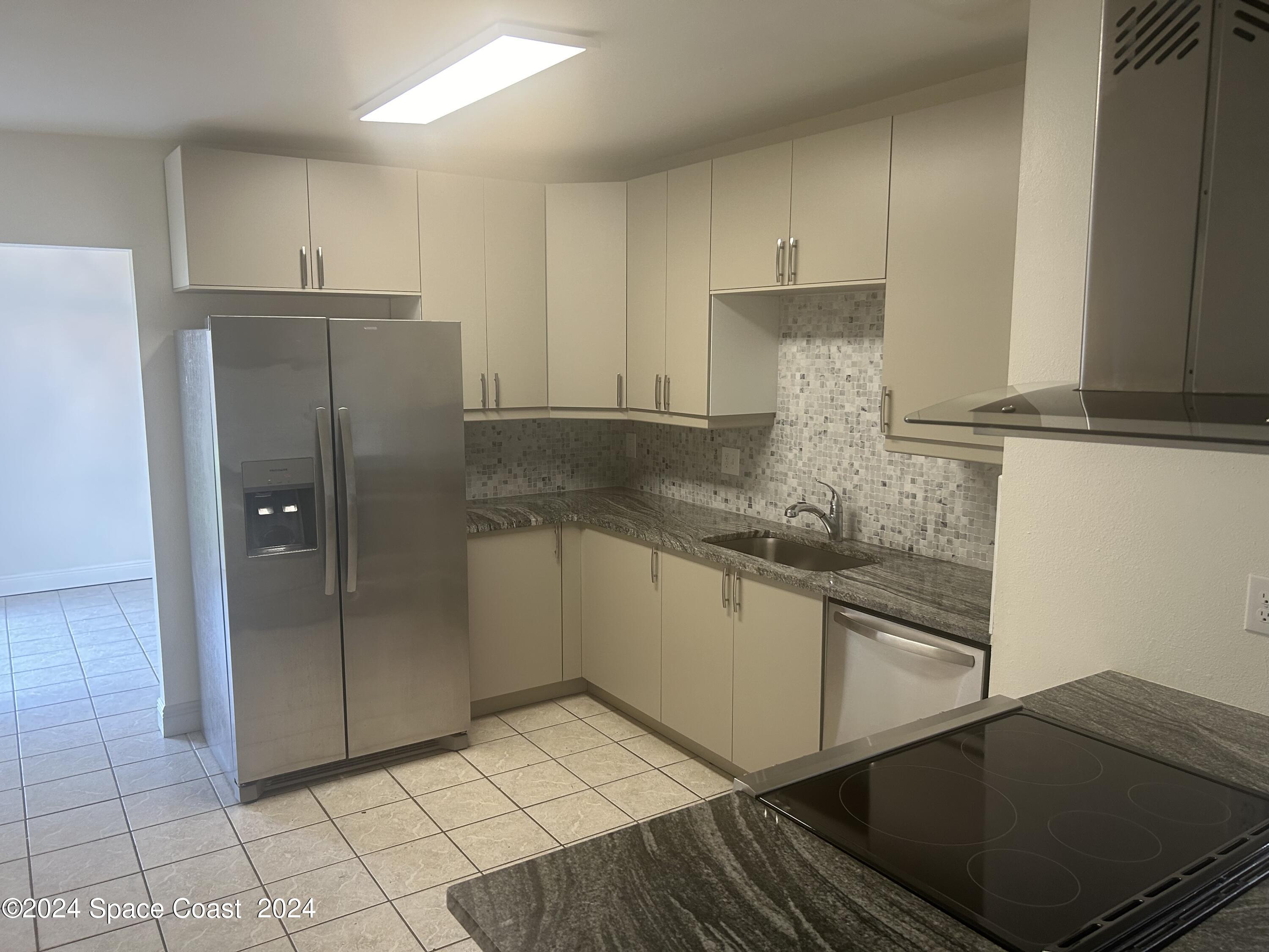 2808 Starlight Circle Northeast Palm Bay, FL 32905 - Photo 2 of 15 a kitchen with stainless steel appliances granite countertop a refrigerator and a stove