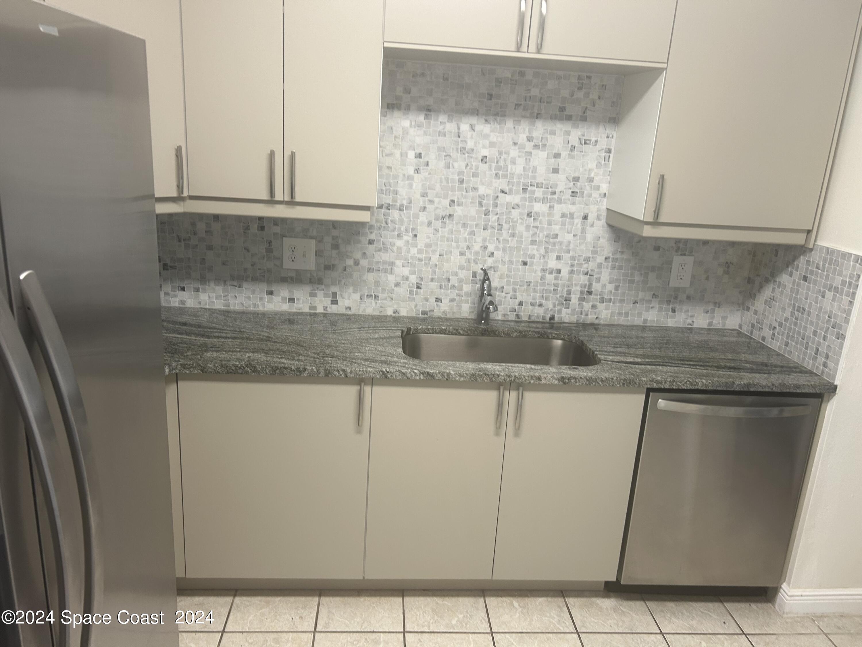 2808 Starlight Circle Northeast Palm Bay, FL 32905 - Photo 3 of 15 a kitchen with granite countertop a sink and a white stove