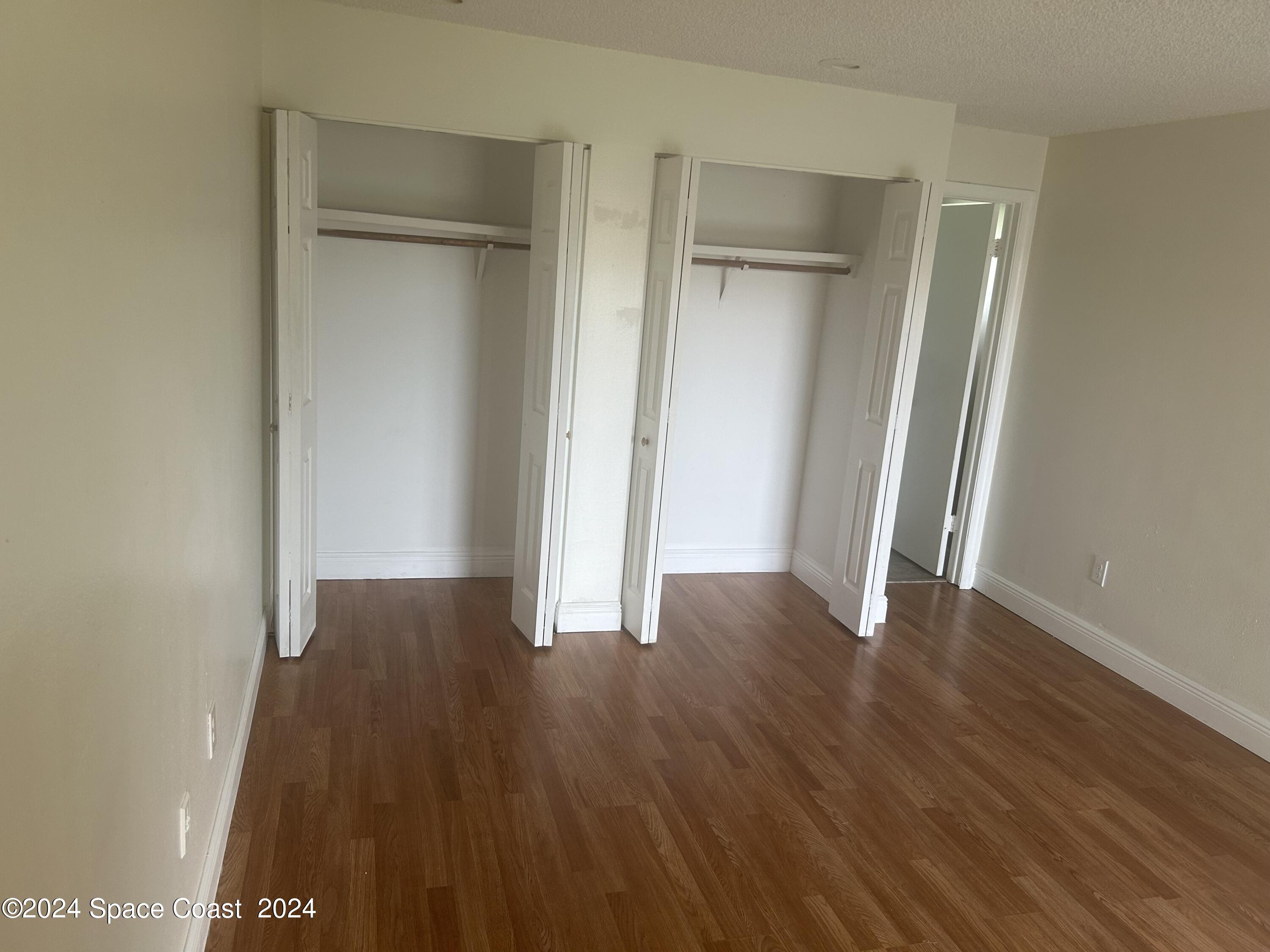 2808 Starlight Circle Northeast Palm Bay, FL 32905 - Photo 8 of 15 a view of an empty room with wooden floor and a window