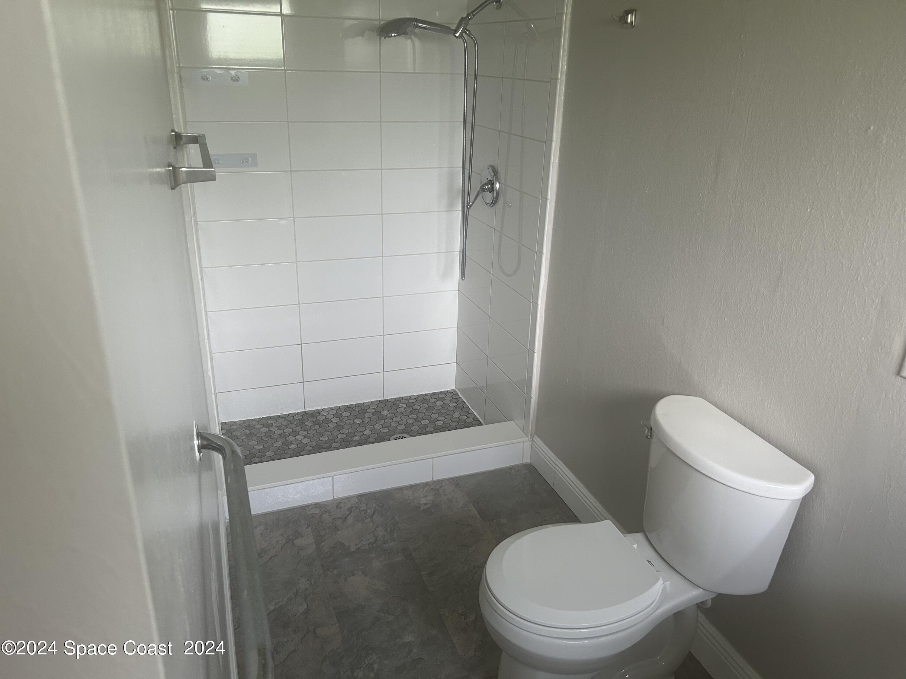 2808 Starlight Circle Northeast Palm Bay, FL 32905 - Photo 9 of 15 a white toilet sitting next to a shower