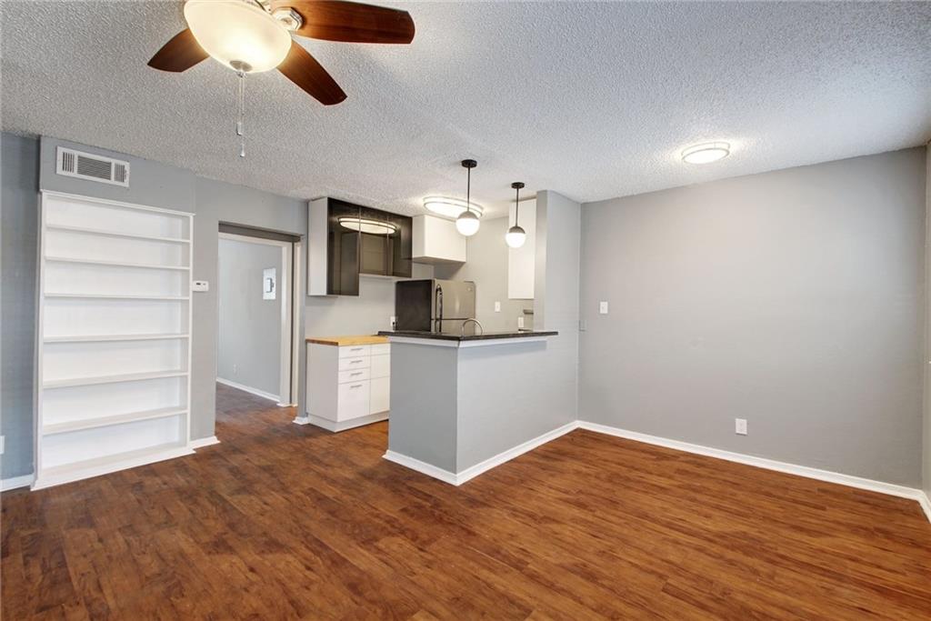 2401 Manor Road, Unit 127 Austin, TX 78722 - Photo 19 of 20 a view of a kitchen with wooden floor and a ceiling fan