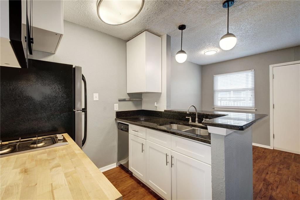 2401 Manor Road, Unit 127 Austin, TX 78722 - Photo 4 of 20 a kitchen with a sink and a refrigerator