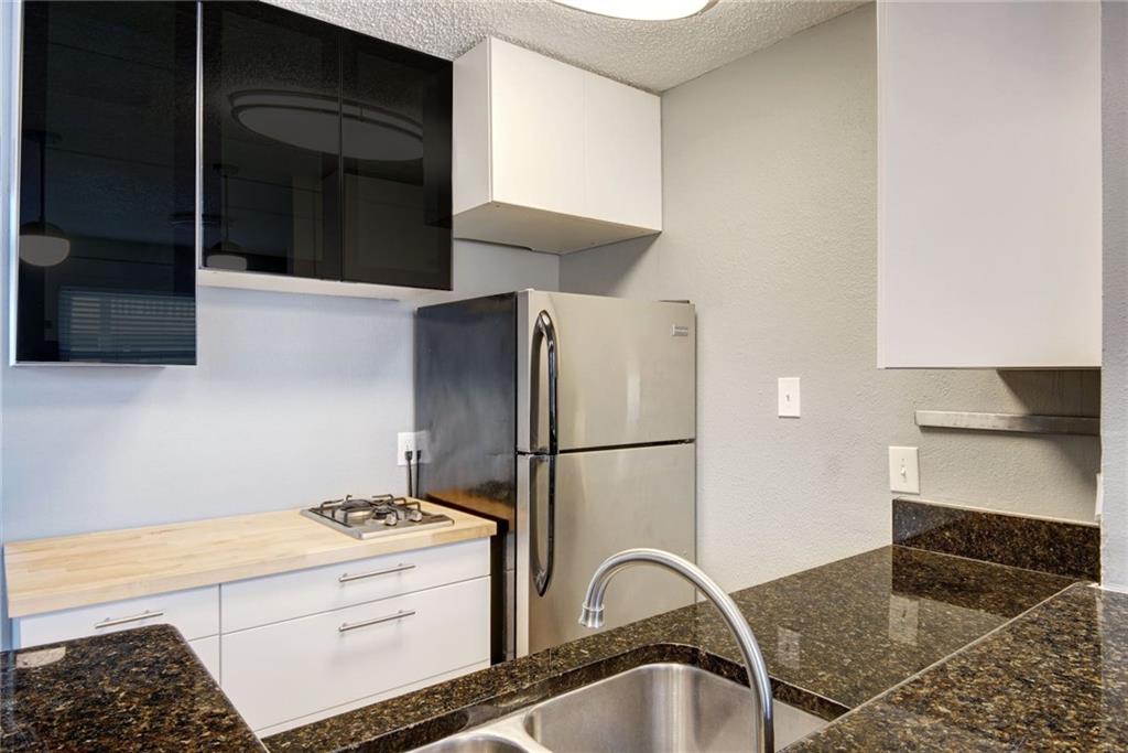 2401 Manor Road, Unit 127 Austin, TX 78722 - Photo 6 of 20 a kitchen with a refrigerator and a stove top oven