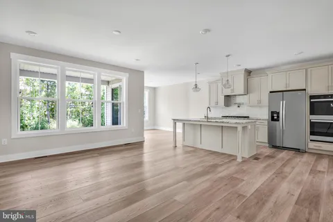 a kitchen with white cabinets and wooden floor