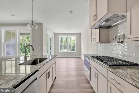 a kitchen with stainless steel appliances a sink stove and cabinets