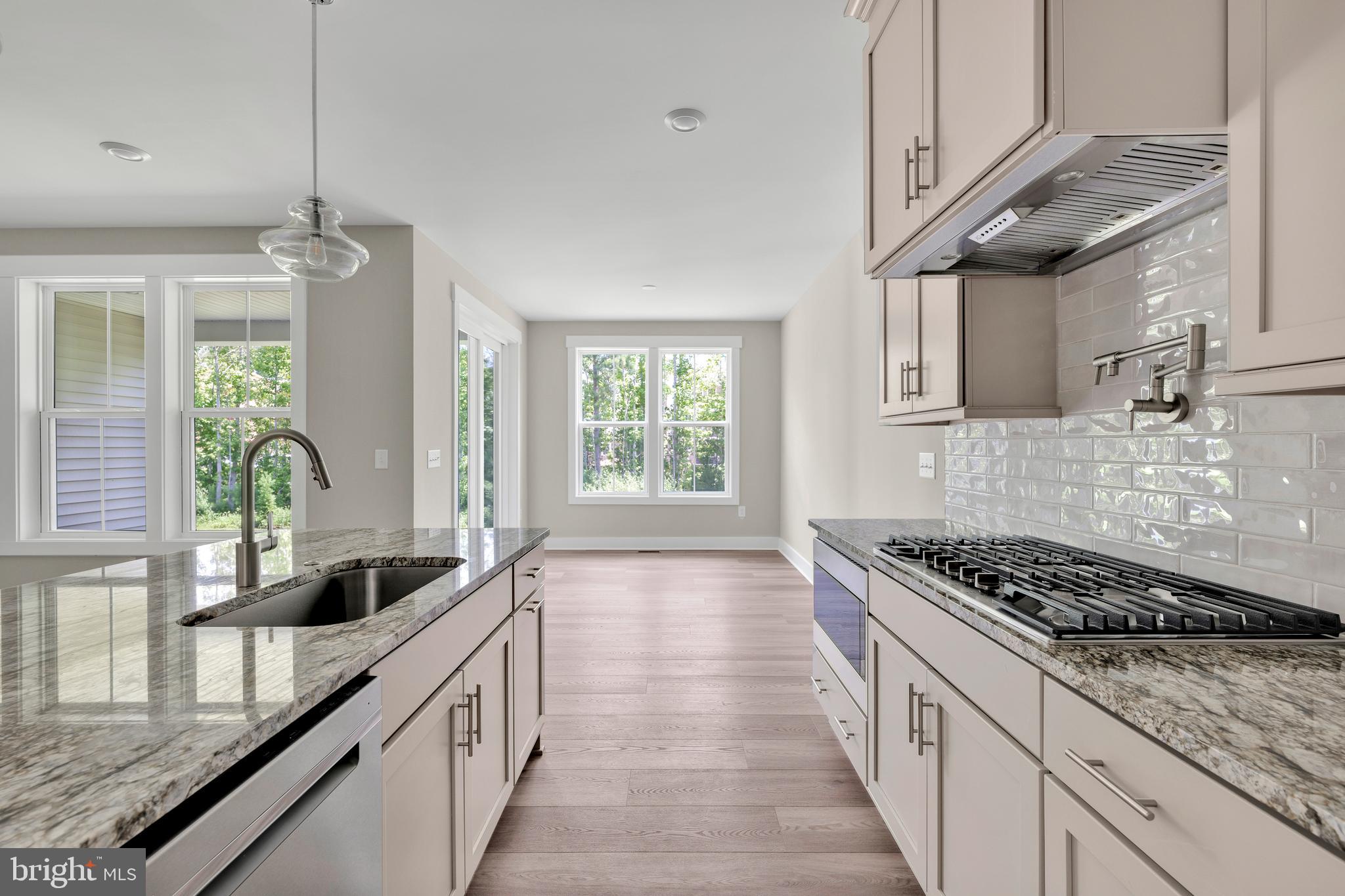 24166 Heartleaf Road Frankford, DE 19945 - Photo 12 of 28 a kitchen with stainless steel appliances a sink stove and cabinets