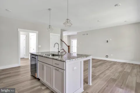 a kitchen with stainless steel appliances granite countertop a sink stove and wooden floor