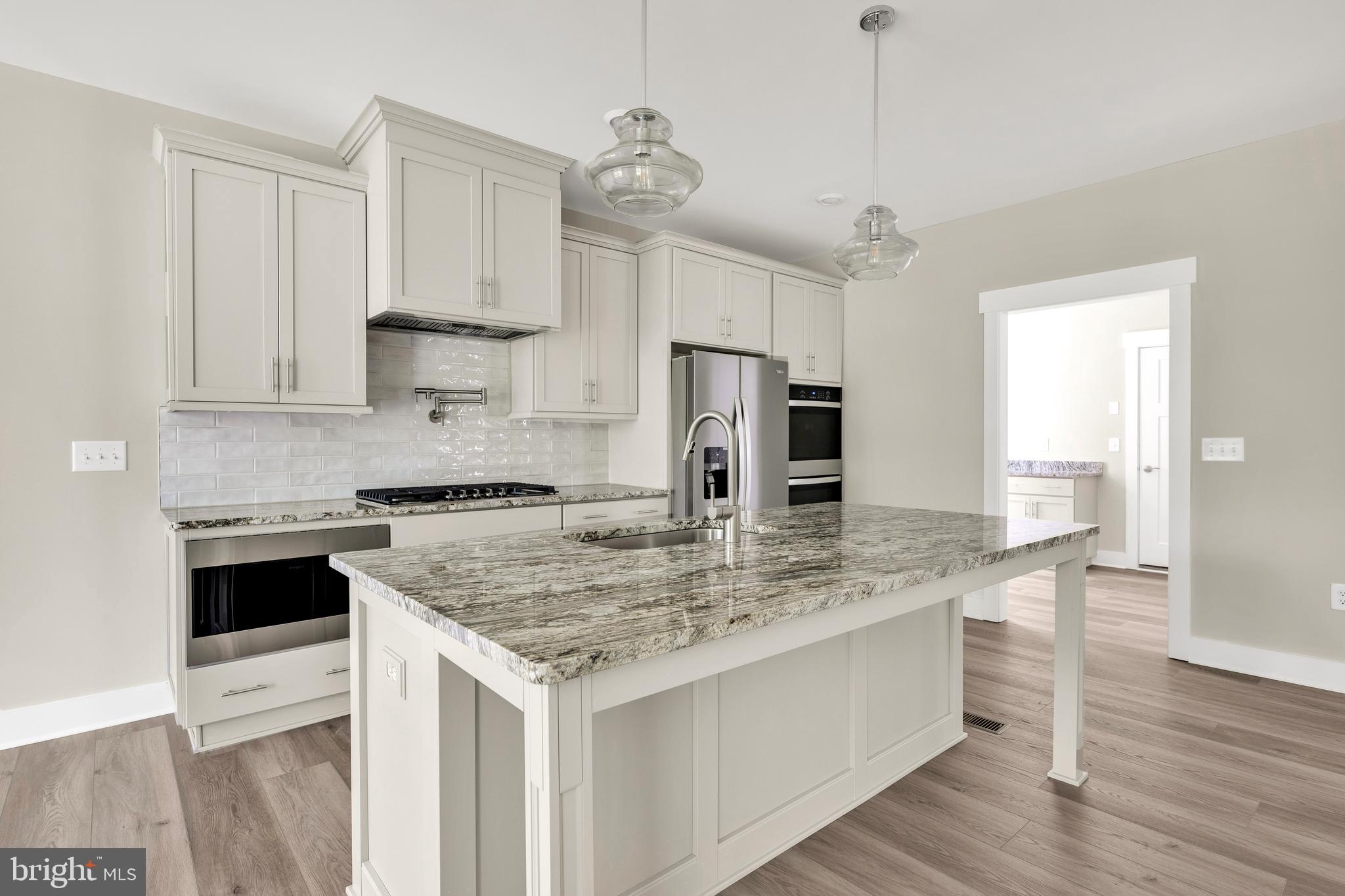 24166 Heartleaf Road Frankford, DE 19945 - Photo 15 of 28 a kitchen with stainless steel appliances granite countertop a sink stove and refrigerator
