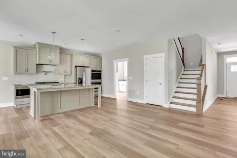 a view of kitchen with granite countertop cabinets and refrigerator