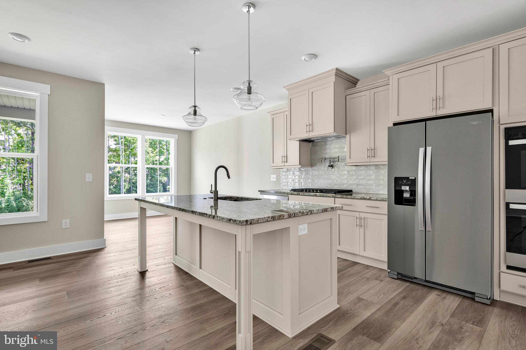 24166 Heartleaf Road Frankford, DE 19945 - Photo 9 of 28 a kitchen with stainless steel appliances granite countertop a refrigerator a sink dishwasher a oven with white cabinets and wooden floor