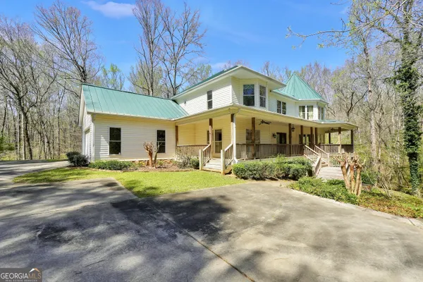 a front view of a house with a yard and trees