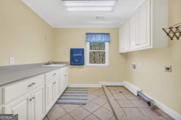 a view of a livingroom with a chandelier fan and windows