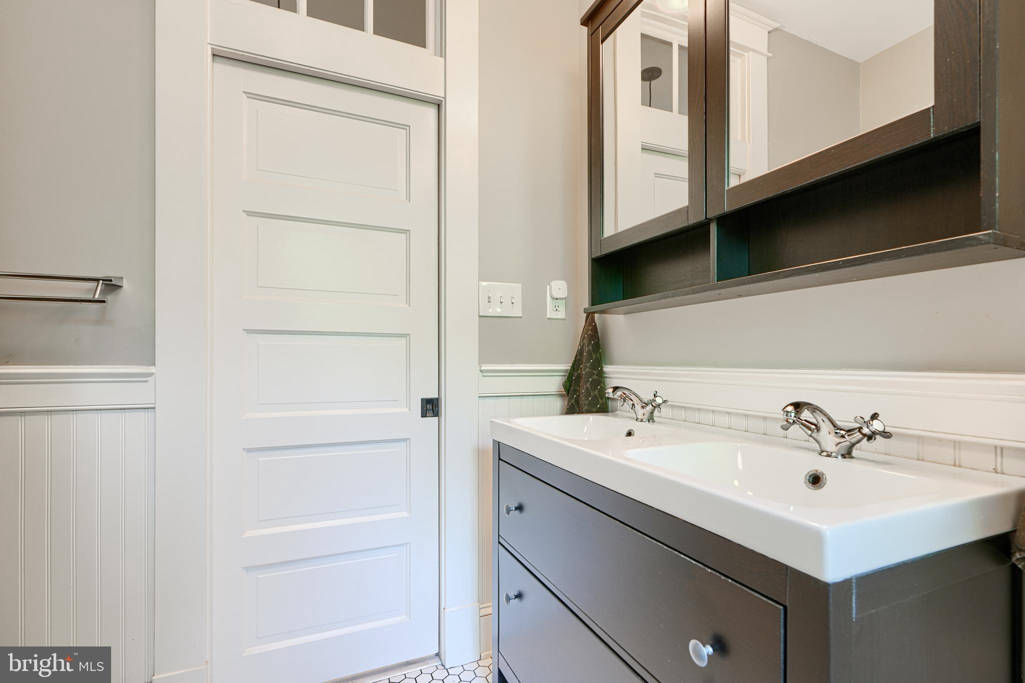 5316 Catalpha Road Baltimore, MD 21214 - Photo 25 of 54 a bathroom with a sink a mirror and a shower