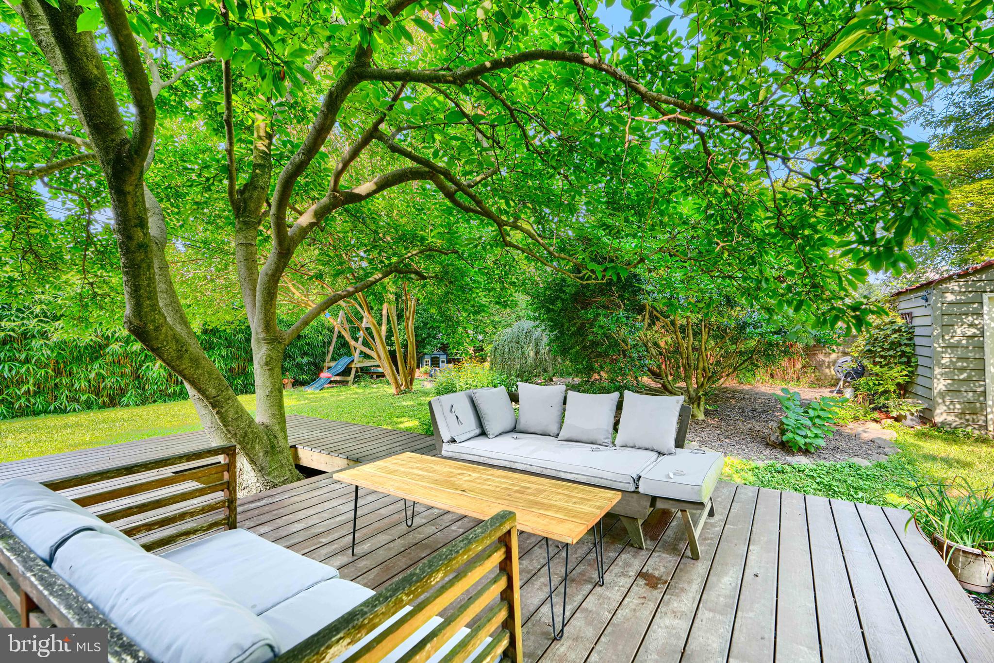 5316 Catalpha Road Baltimore, MD 21214 - Photo 46 of 54 a view of a patio with couches table and chairs and potted plants with large trees