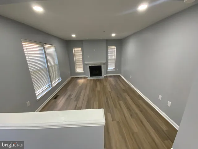 a view of empty room with wooden floor and fireplace