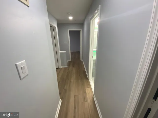 a view of a hallway with wooden floor and entryway