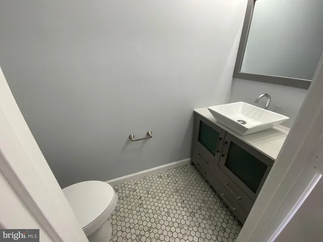 a bathroom with a sink a toilet a mirror and vanity