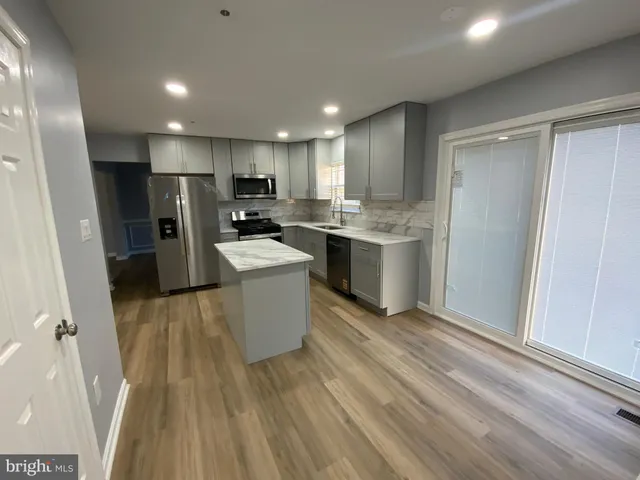a kitchen with a sink stainless steel appliances a refrigerator and cabinets