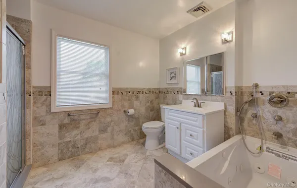 a bathroom with a double vanity sink toilet and shower