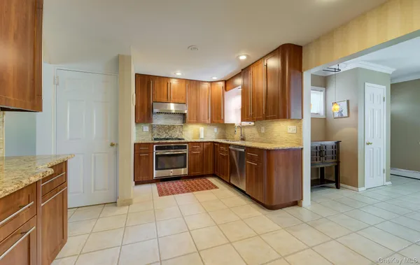 a kitchen with stainless steel appliances granite countertop a stove a sink and a refrigerator