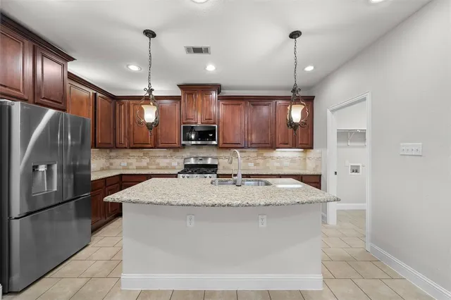 a large kitchen with cabinets a sink and stainless steel appliances