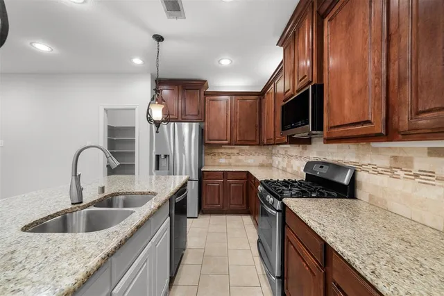 a kitchen with stainless steel appliances granite countertop a sink stove and refrigerator