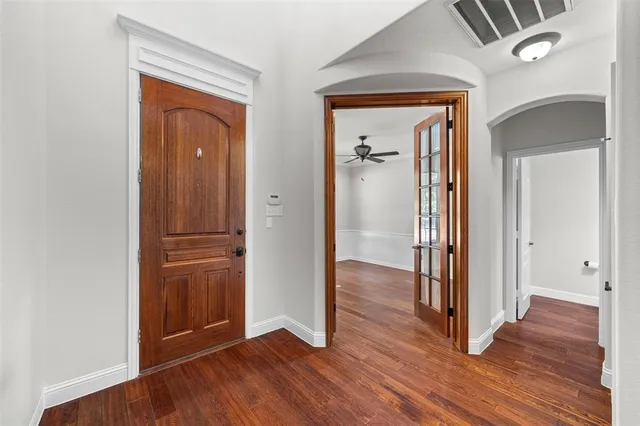 an empty room with wooden floor & a mirror