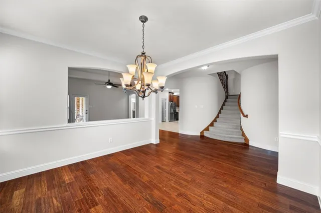 a view of a livingroom with wooden floor and a chandelier