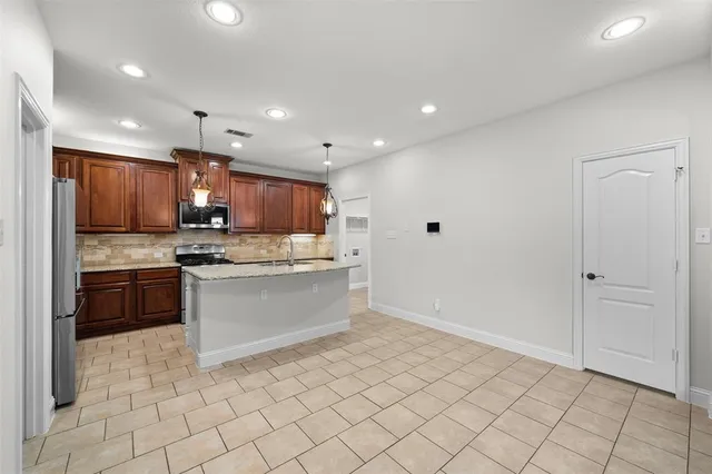 a large kitchen with a large counter top appliances and cabinets