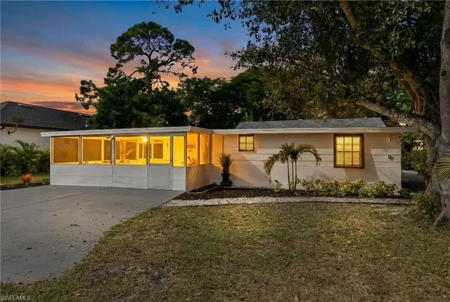 a view of swimming pool with lawn chairs and plants