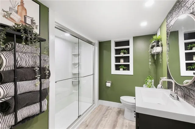 a bathroom with a sink a toilet and shower