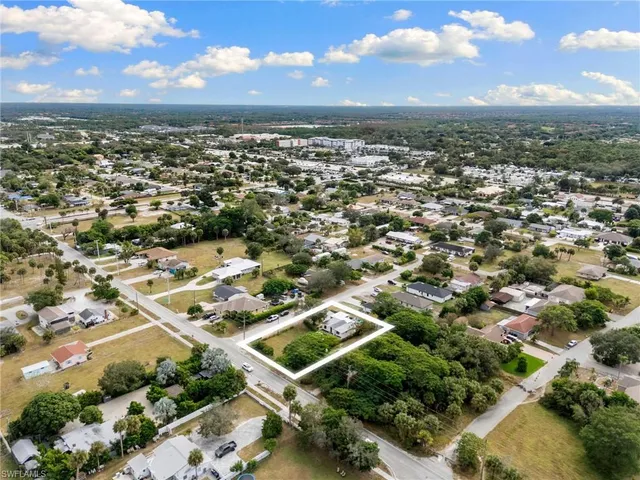 an aerial view of residential houses with outdoor space and trees