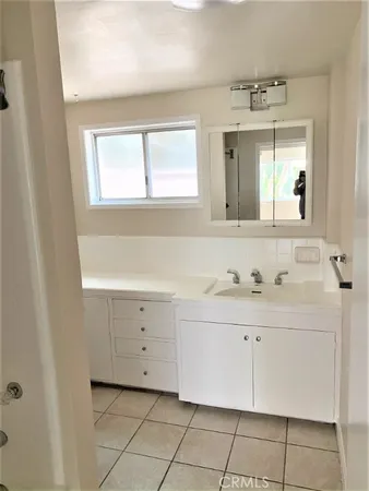 a bathroom with a sink vanity and mirror